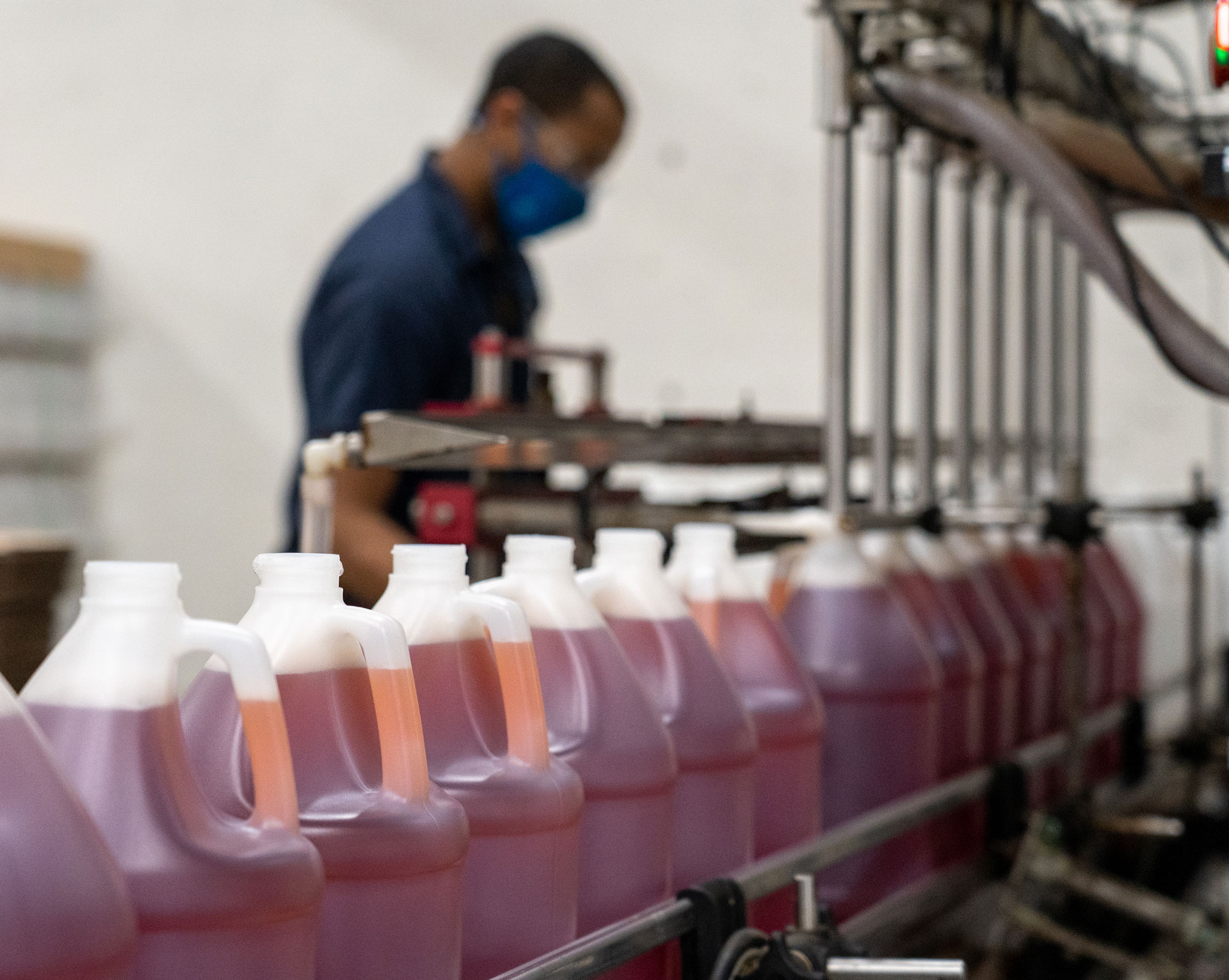 A line of bottles being filled with cleaning solution.